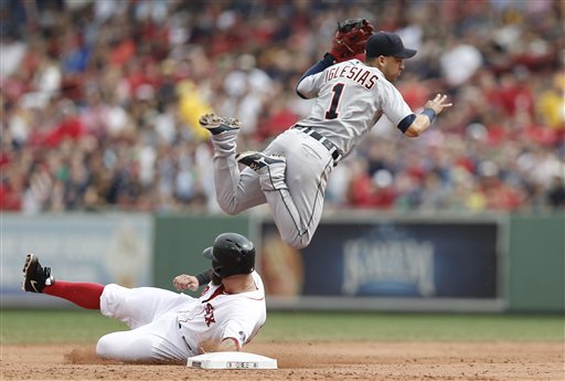 Detroit Tigers shortstop Jose Iglesias turns a double play over the slide of Boston Red Sox first baseman Mike Napoli during the second inning Monday at Fenway Park in Boston. The Tigers won 3-0.