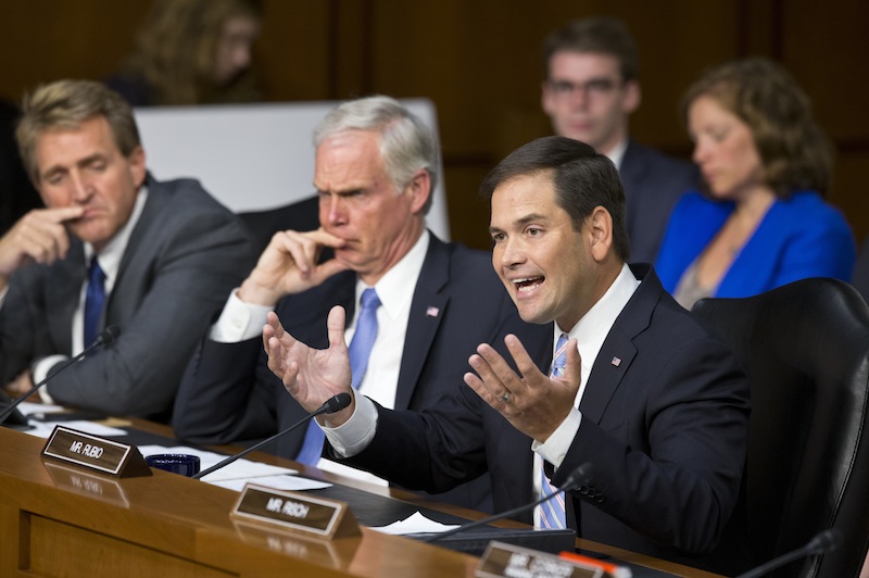 Senate Foreign Relations Committee member Sen. Marco Rubio, R-Fla., joined by fellow committee members, Sen. Ron Johnson, R-Wis., center, and Sen. Jeff Flake, R-Ariz., questions Secretary of State John Kerry during committee's hearing on President Barack Obama's request for congressional authorization for military intervention in Syria, a response to last month's alleged sarin gas attack in the Syrian civil war, Tuesday, Sept. 3, 2013, on Capitol Hill in Washington. (AP Photo/J. Scott Applewhite)