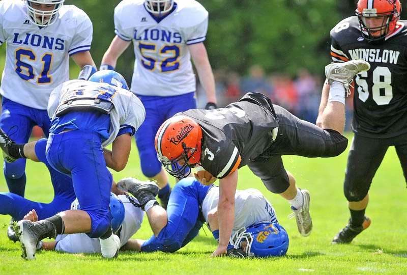 Staff photo by Michael G. Seamans Winslow High School running back Dylan Hapworth, 3, dives over a Belfast High School defender in the first quarter in Winslow on Saturday.