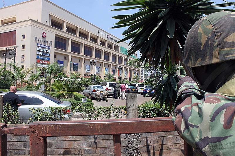A soldier aims his weapon outside the Westgate Mall, an upscale shopping mall in Nairobi, Kenya on Saturday, where shooting erupted when armed men staged an attack. A witness to the attacks at Nairobi's upscale mall says that gunmen told Muslims to stand up and leave and that non-Muslims would be targeted. Initial police reports had described the incident as a botched robbery. Witnesses say a half dozen grenades also went off along with volleys of gunfire in and around the mall.