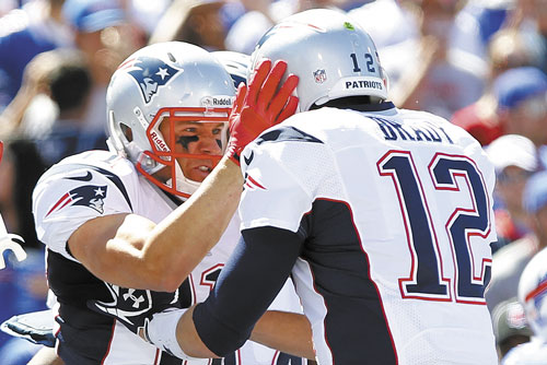 NICE PASS: New England’s Julian Edelman, left, celebrates with teammate Tom Brady, right, after catching a touchdown pass during the first half against Buffalo on Sunday in Orchard Park, N.Y.