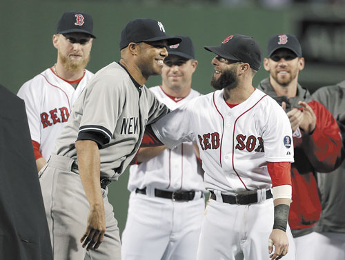 CONGRATULATIONS: New York Yankees relief pitcher Mariano Rivera, left, embraces Boston Red Sox’s Dustin Pedroia, right, during a tribute to Rivera before the start of Sunday night’s game at Fenway Park in Boston.