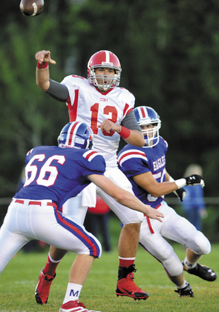 BIG PLAY: Cony High School quarterback Ben Lucas, 13, center, unloads the ball before getting hit my Messalonskee High School defenders Caleb Bean left, and Jordan Carson, in the first quarter on Friday at Messalonskee High School in Oakland.