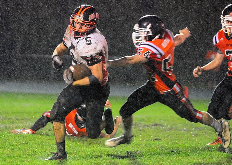 Brunswick's Lucas McCue runs away from Gardiner's Walker Norton during the Dragons' 54-0 win over the Tigers on Friday at Hoch Field in Gardiner.