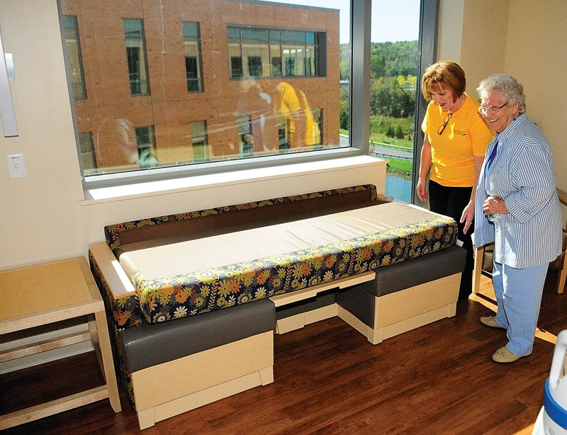 Nurse manager Edie Welch shows her mother, Lillian Merrill, how a couch in a patient room folds into a bed during a tour of the Alfond Center for Health today in Augusta. Welch was giving tours of the David M. Dick Memorial Wing, which is named in honor of a late nurse who worked for the hospital for 20 years.