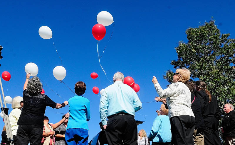 People watch a balloon release following the groundbreaking ceremony for the Maine chapter of Parents of Murdered Children's new monument today in Holy Family Cemetery in Augusta.