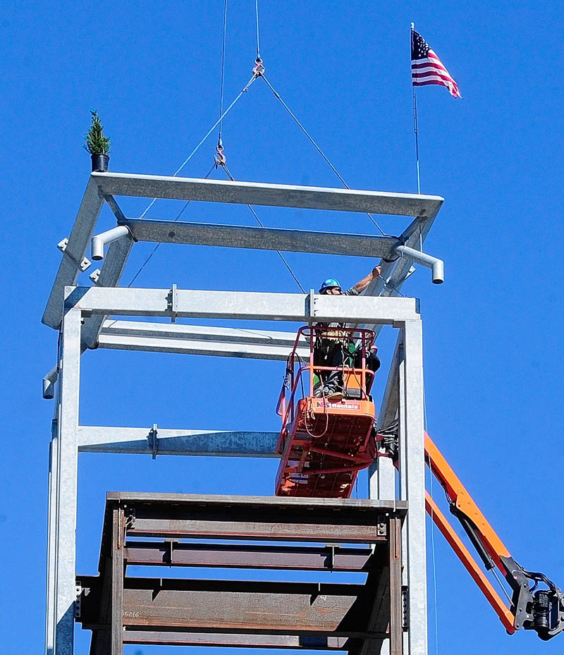 Construction workers guide the last beam into place on Wednesday at the new consolidated courts building being built in Augusta.
