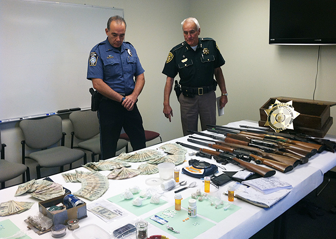 Kennebunk Lt. Daniel Jones, left, and York County Sheriff Maurice Ouellette display drugs and weapons seized during a search at a suspected drug house in Kennebunk. Photo provided by York County Sheriff's Office.
