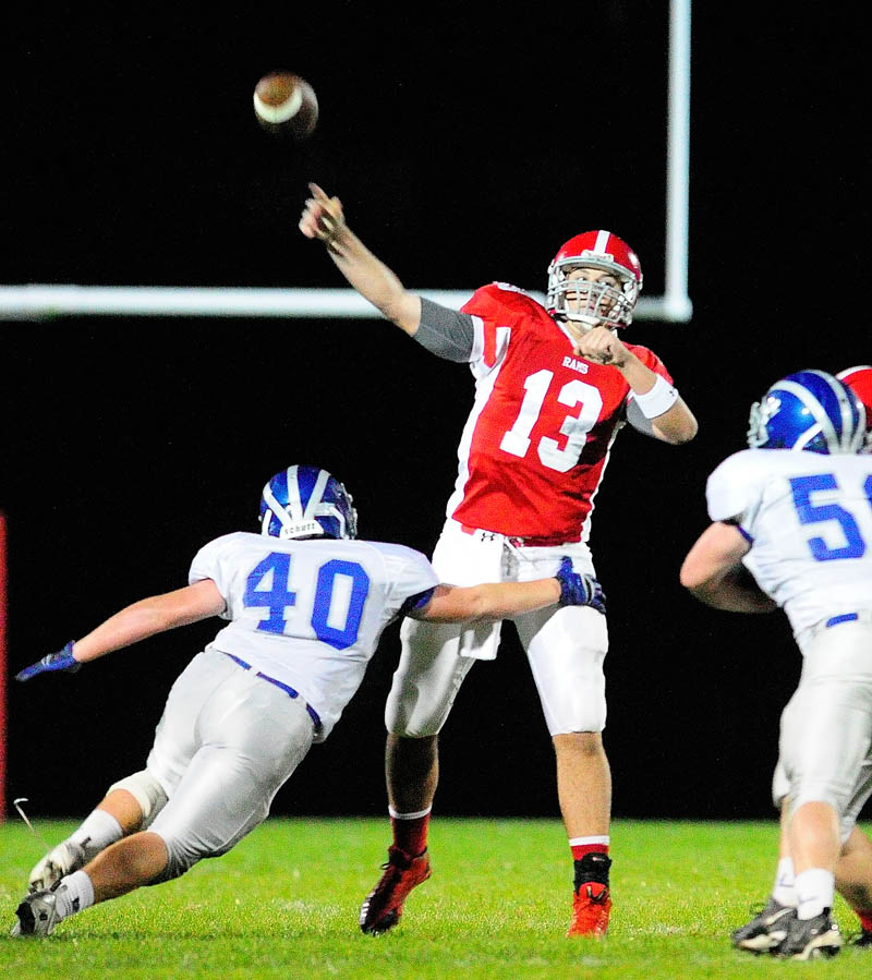 Cony quarterback Ben Lucas, middle, throws a touchdown pass under pressure from Lawrence's Cole Robinson, left, and Kyle McLain during a game on Friday September 27, 2013 at Alumni Field in Augusta. He completed a a 37 yard touchdown to Jonathan Saban.