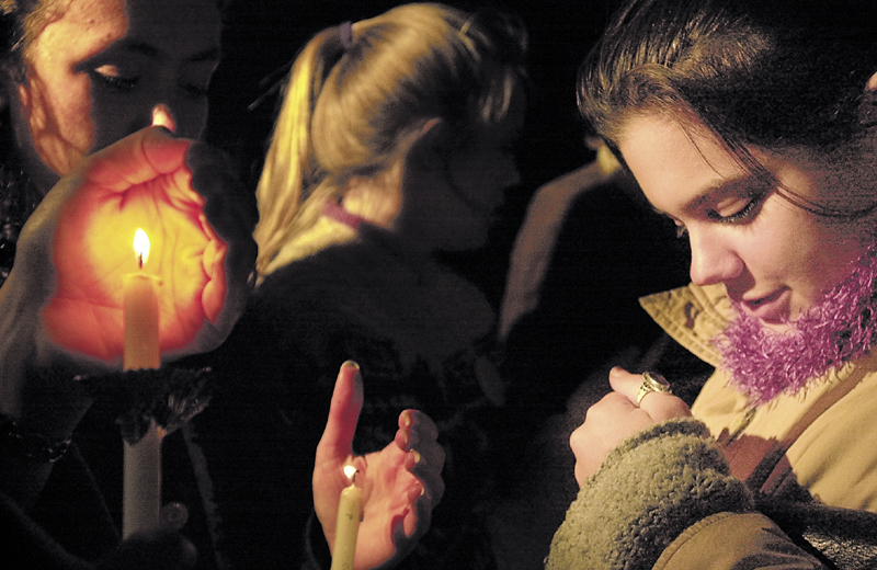 Sarah Kaminshine, right, then a Colby College senior, tries to protect her candle from the wind during a vigil outside Anthony Mitchell Schupf dormitory in memory of Dawn Rossignol on Sept. 18, 2003, in Waterville.