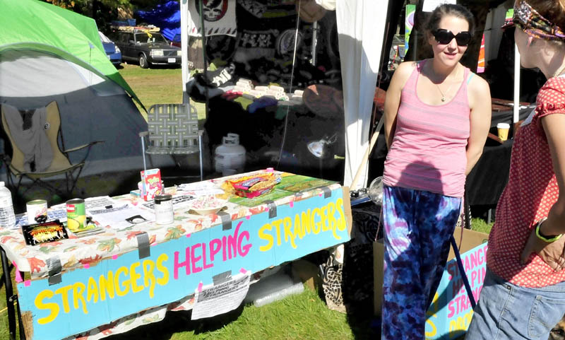 Andie Burke, left, speaks with Casey Joudrey at the Strangers Helping Strangers booth during the Great North Fest in Norridgewock today. The Massachusetts nonprofit attends concerts and festivals, collecting donated or leftover, nonperishable food and hygiene products, which it donates to pantries.