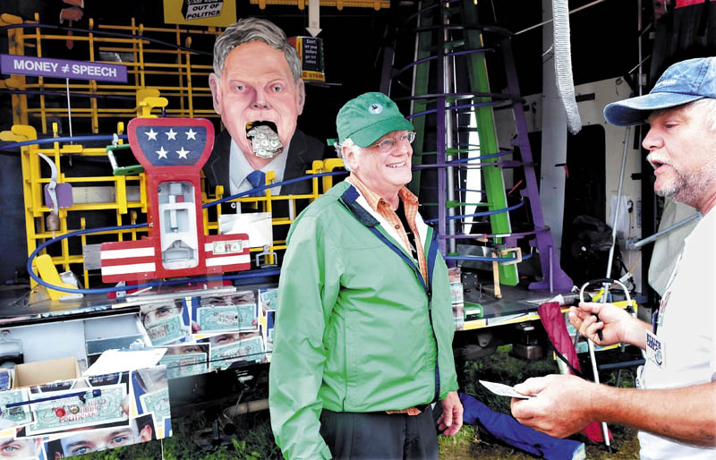 Ben Cohen, left, cofounder of Ben and Jerry's Ice Cream, speaks with George Stanley at his booth, featuring the Amend-O-Matic StampMobile, at the Common Ground Country Fair in Unity today.