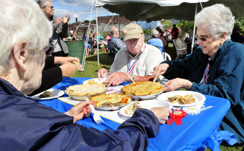 Judges for the popular French dish tourtiere begin to sample entries in the best pie contest during the Franco-American Family Festival in Waterville today. From left are Cecile Vigue, Reginald Dumont and Rita Hikel. Janette White won first place, followed by Karen Rancourt-Thomas and Sandra Leighton.