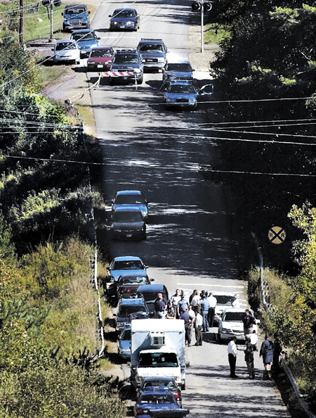 State Police investigators, Waterville and Oakland police assembled at the base of the Rice Rips Road in Oakland on Sept. 17, 2003, to investigate the discovery of Colby College student Dawn M. Rossignol, who was found found dead that morning.