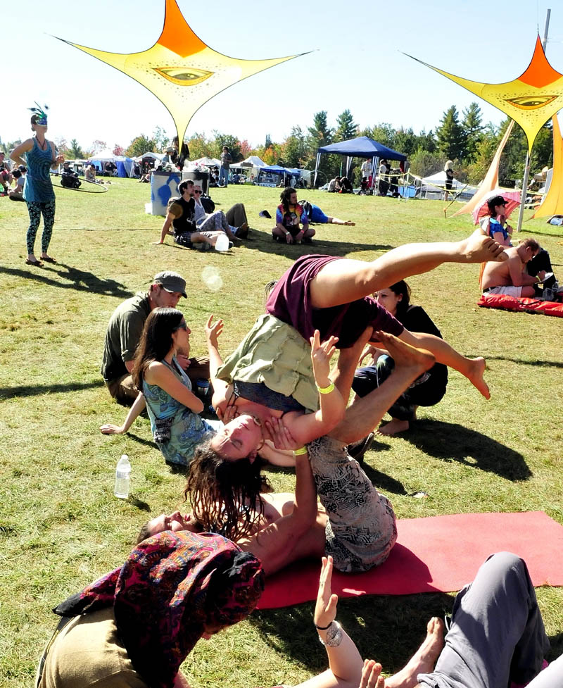 Yoga instructor Denise Porter Kemp is held up by Dave Melnick while doing partner acrobatics, as music played during the Great North Fest in Norridgewock today. Organizers estimated 1,500 people attended the three-day event.