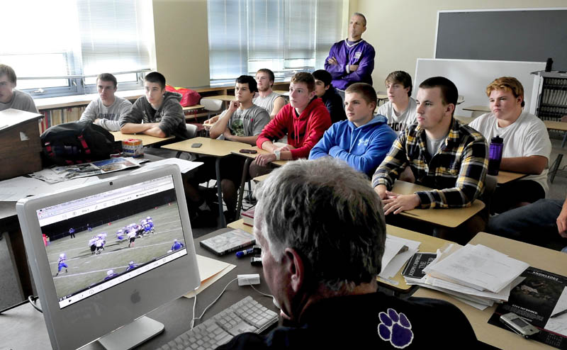 PLAYBACK: Waterville football offensive coordinator Ken Lindlof monitors a game video as players and head coach Frank Knight, standing, watch it on a larger screen Wednesday at the high school.