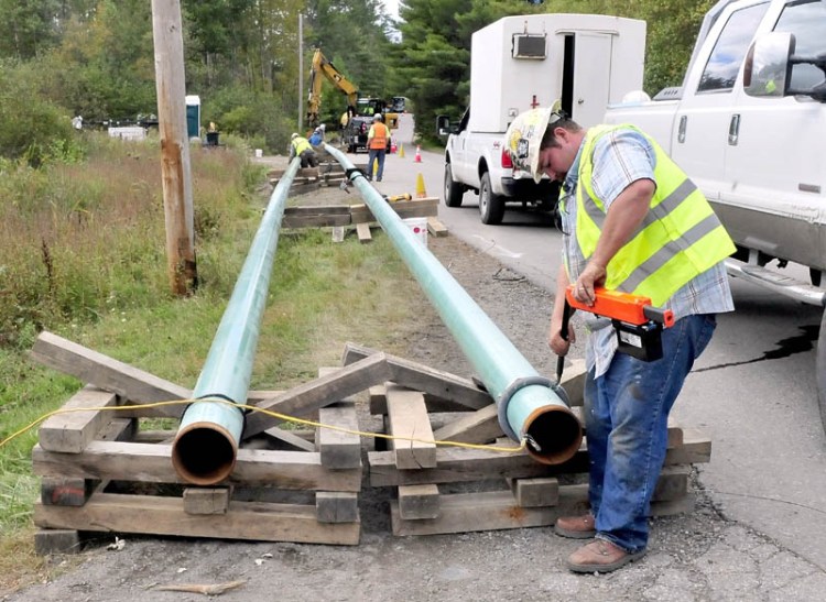 Jeremy Clubbs, of sub-contractor U.S. Pipelines, works on preparing to install gas pipeline sections outside Sappi Fine Paper in Skowhegan in this 2014 file photo.