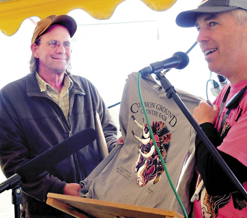 Common Ground Country Fair Director Jim Ahearne, right, present this years fair T-shirt to keynote speaker George Siemon, cofounder of the Organic Valley cooperative, following his talk at the Unity fair today.