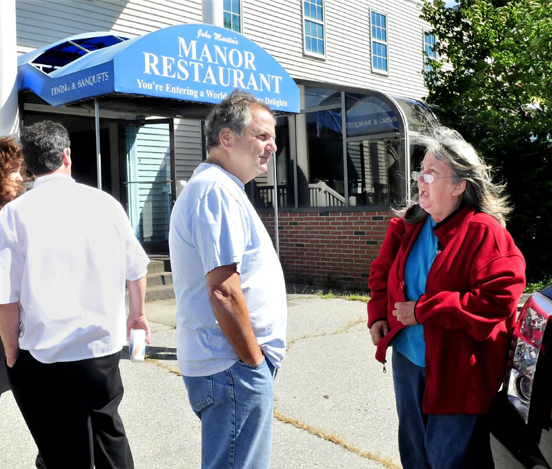 Peter Martin, whose family owned the former John Martin's Manor in Waterville, speaks with long-time employee Amanda Proctor outside the business at today's auction of the property.
