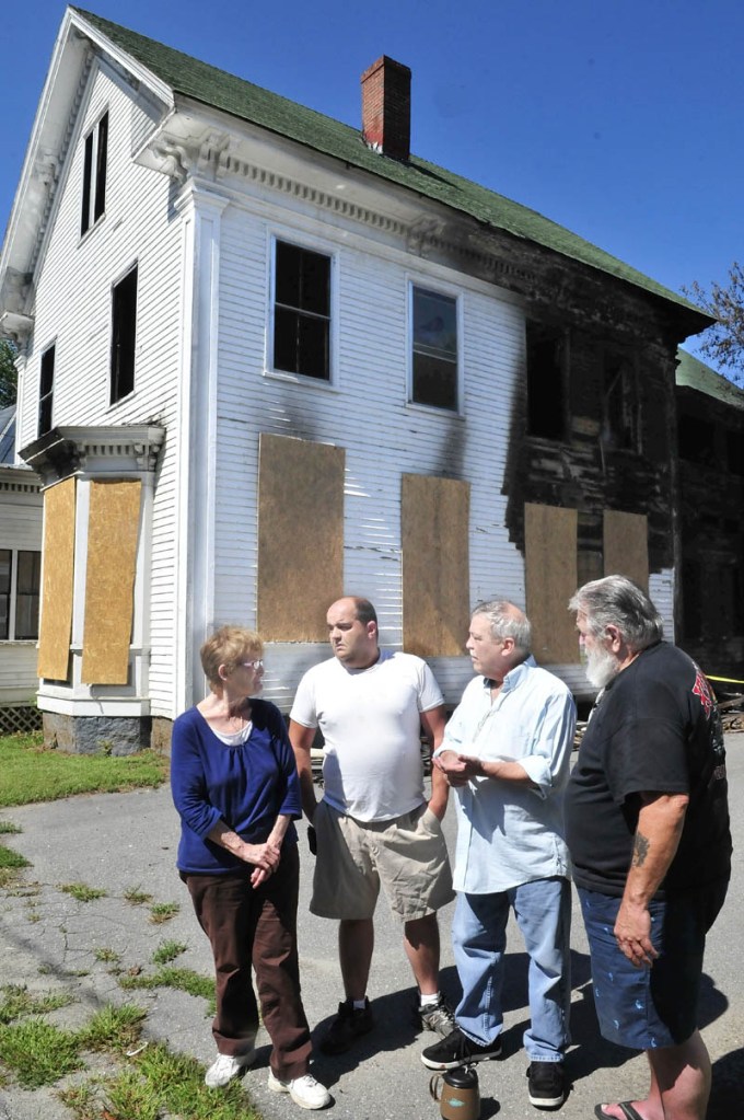 These Elm Court residents are concerned about the standing remains of this burned out home that was destroyed by a fire August 25 in Waterville. Authorities have determined it was set intentionally. From left are Patricia Farnsworth, Randy Frappier, Wes Berry and Chris Carpenter.