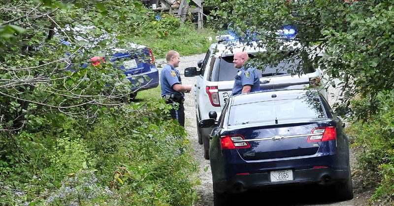 Madison and Skowhegan police gather on Monday near a car, at left, that was reportedly stolen in Madison and then later abandoned in Skowhegan after a high-speed chase. The driver of the car was arrested.