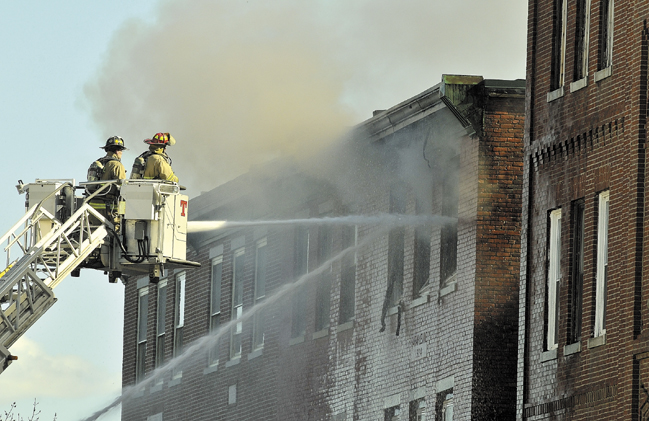 Waterville firefighters battle a fire at 18 Main St. on May 3. That fire has prompted the City Council to consider on Tuesday mandating sprinkler systems, inspections and other safety measures for downtown buildings.