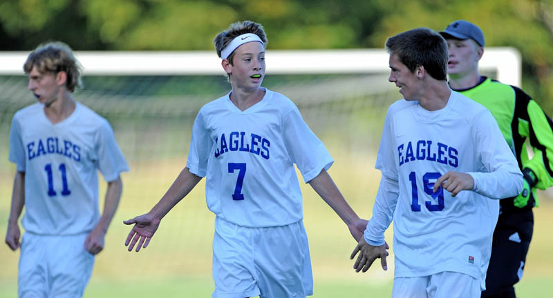 GOOD JOB GUYS: Erskine Academy’s Kyle Zembroski (7) congratulates teammates Phoenix Throckmorton, left, and Mark Buzzell, right, after they beat Mt. View High School 2-1 on Tuesday at Erskine Academy in South China.