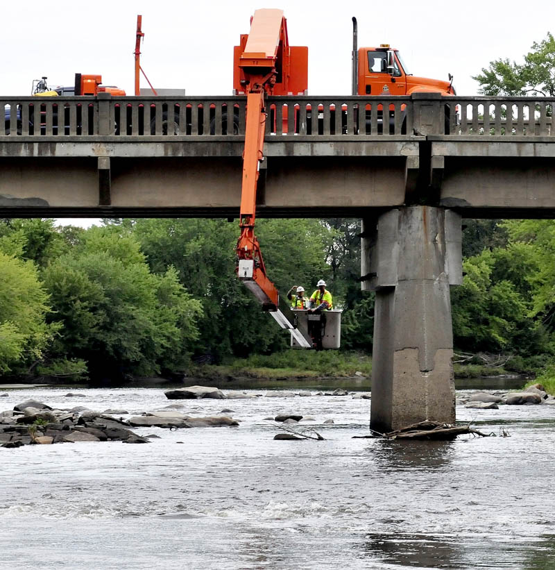 Maine Department of Transportation workers inspect the condition of the underside of the Harry Bridge over Sandy River in Farmington Falls today.