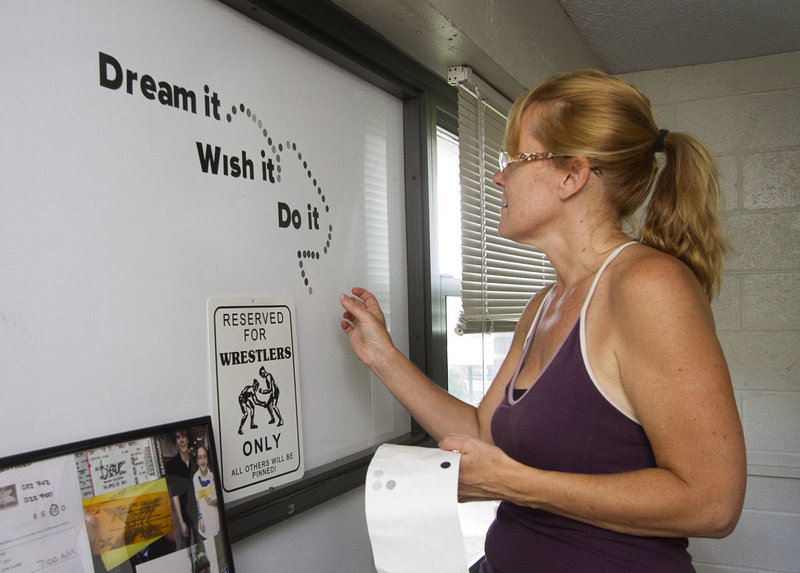 Linda Bonina of Hudson, Mass., decorates the white board in her son Vinny's USM dorm room with some words of inspiration Sunday. "I found this and want him to read this every day," she said of the quotation.