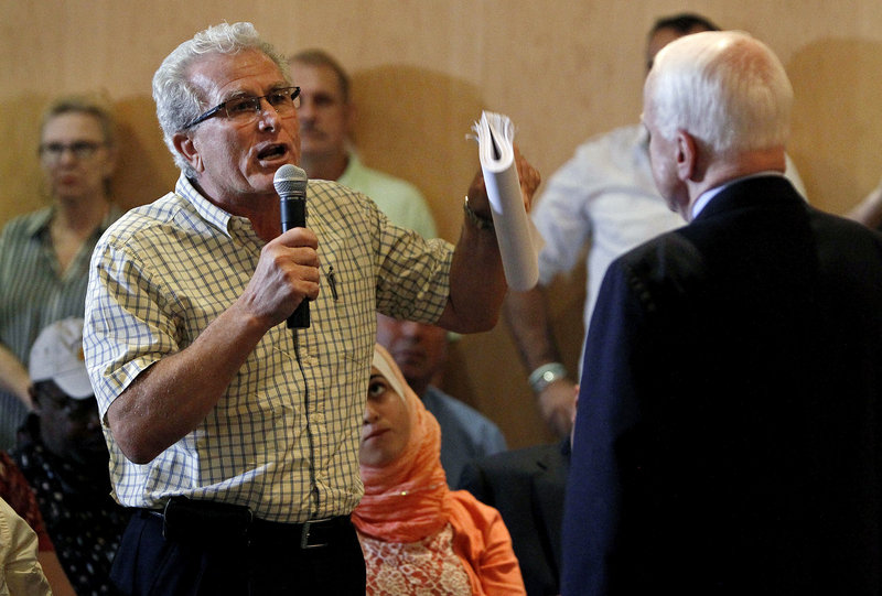 Sen. John McCain, right, who generally supports President Obama’s stance, hears a dissenting point of view from constituent Albert Moussa earlier this week during a town hall meeting in Phoenix that was supposed to concern various issues but quickly focused on possible military action against Syria.