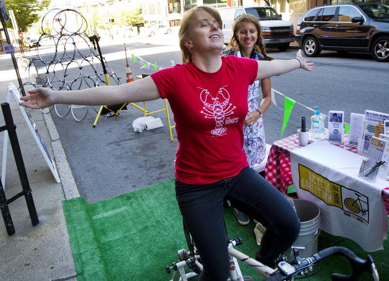 Elizabeth Hall of the Bicycle Coalition of Maine enjoys a peddle in a parking space outside the organization's Preble Street office, during Portland's second annual Park(ing) Day on Friday, September 20, 2013. Taking place in nearly 200 cities around the world, people take over parking spaces for to hang out and have fun.