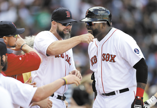 STILL ROLLING: Boston’s designated hitter David Ortiz, right, is welcomed to the dugout by David Ross, center left, after Ortiz hit a home run during the Red Sox’ 5-2 win over Toronto on Sunday in Boston. The Red Sox aved wrapped up the AL East title and won’t play their first playoff game for nearly two weeks, but continue to try to win.