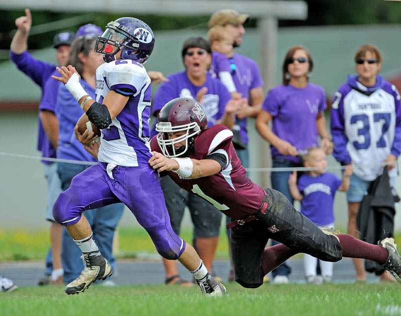 Waterville’s Dalton Denis, left, breaks the grasp of Nokomis’ Ray Girroir on his way to a touchdown on a punt return Saturday at Nokomis High School in Newport.