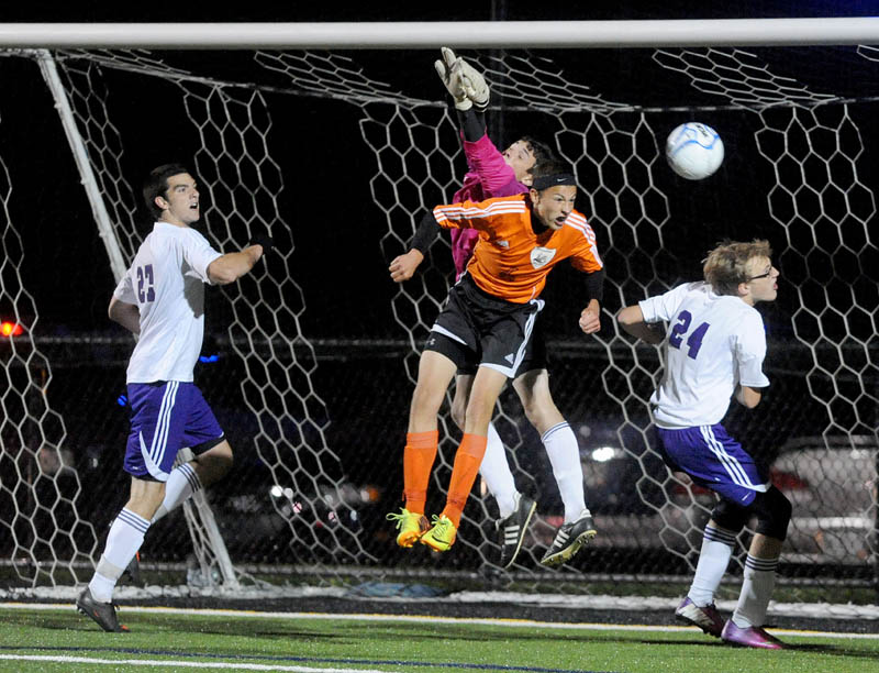 Waterville Senior High School goalie Liam Edwards, tries to punch the ball away from the net as Winslow High School's Logan Vachon, 6, tries to head the ball in the goal in the first overtime in Class B soccer action Tuesday at Thomas College in Waterville. Waterville and Winslow tied 0-0 in double overtime.
