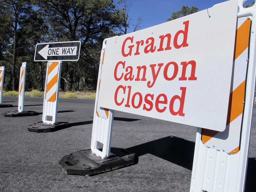 This Oct. 3, 2013, photo shows a sign at the south entrance to Grand Canyon National Park, Ariz. October is normally a peak month for tourism in many parts of the West.