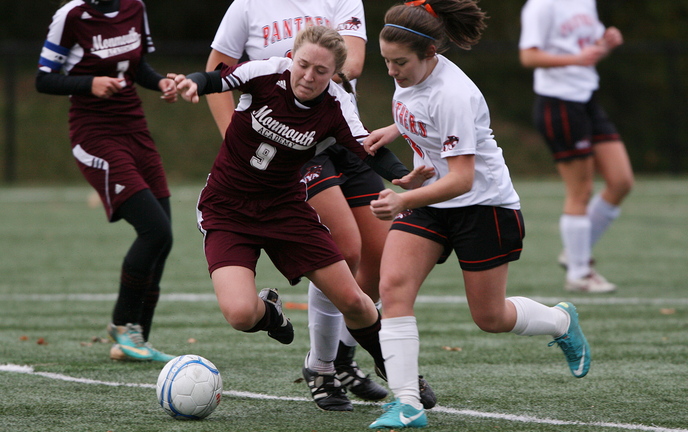 Madison Bumann, left, of Monmouth Academy stumbles as she fights for the ball with North Yarmouth Academy’s Jennifer Machin during their Western Class C girls’ soccer prelim Friday afternoon in Yarmouth. Monmouth won in overtime, 1-0.