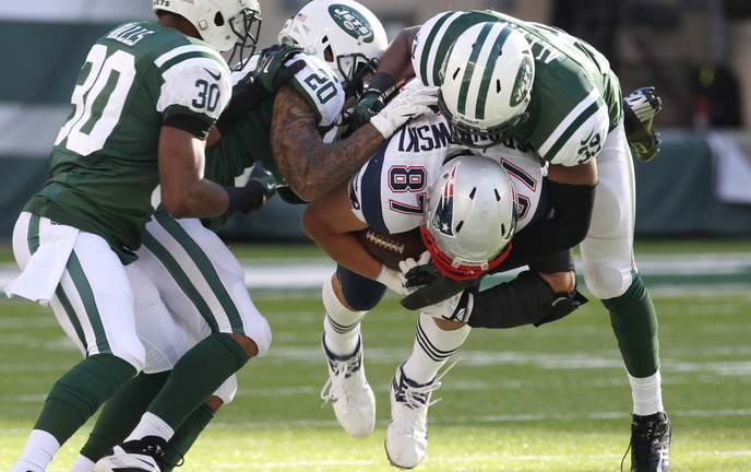 Triple-teamed by Jets Darrin Walls, Kyle Wilson and Antonio Allen, the Patriots’ Rob Gronkowski goes down after catching a pass in Sunday’s game. Gronkowski caught eight passes in his long-awaited return, but a crucial drop factored in New England’s loss.