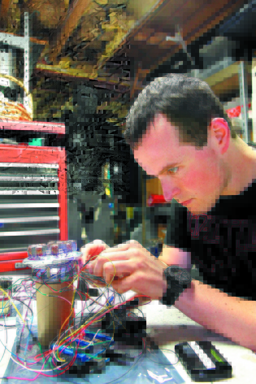 Invention: Oakland resident Thomas Lemieux works on one of the electronic components of his Iron Man suit during the summer.