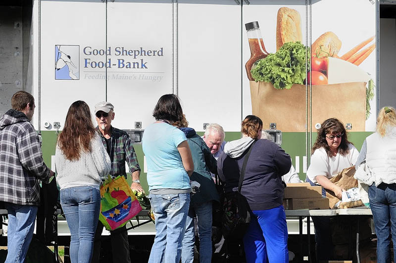 Volunteers hand out food during a Good Shepherd Food Bank food mobile event on Friday at Mill Park in Augusta.
