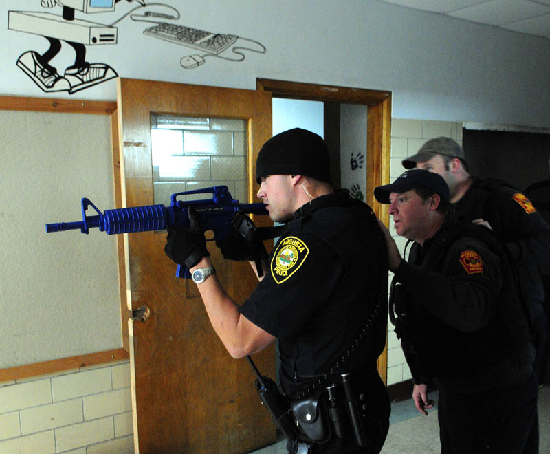 Augusta Police officer Nico Hample, left, leads Augusta firefighter/paramedics John Robertson and Jason Decker as they move down a hallway during a training exercise Friday at the former Hodgkins middle school in Augusta.