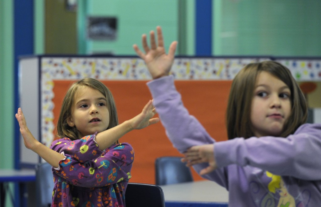 In this photo taken Oct. 9, 2013, Grace Whittaker, left, and Andria Kirkendall, right, learn sign language during a lesson at a homeschooling co-operative at Andrews Air Force Base Md. A growing number of military parents have embraced homeschooling, seeking to put an end to the age-old tradition for military kids of switching schools.