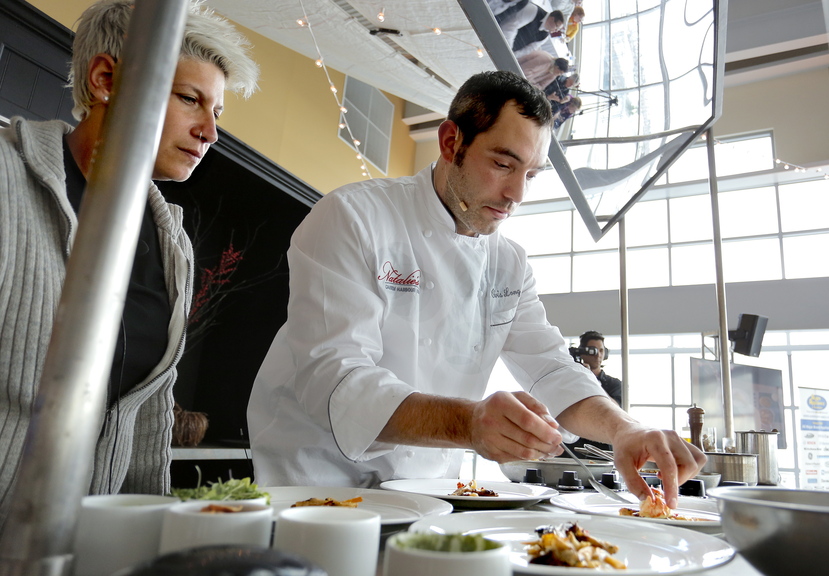 Chef Chris Long of Natalie’s at Camden Harbour Inn plates his winning dish of butter-poached Maine lobster during the Lobster Chef competition at Portland’s Ocean Gateway on Thursday, as emcee Michele Ragussis looks on.