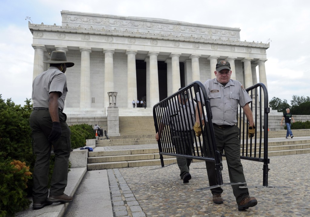 National Park Service employee James Mitchell, right, and others remove barricades from the grounds of the Lincoln Memorial in Washington on Thursday. Barriers went down at National Park Service sites and thousands of furloughed federal workers returned to work throughout the country Thursday after 16 days off the job because of the partial government shutdown.