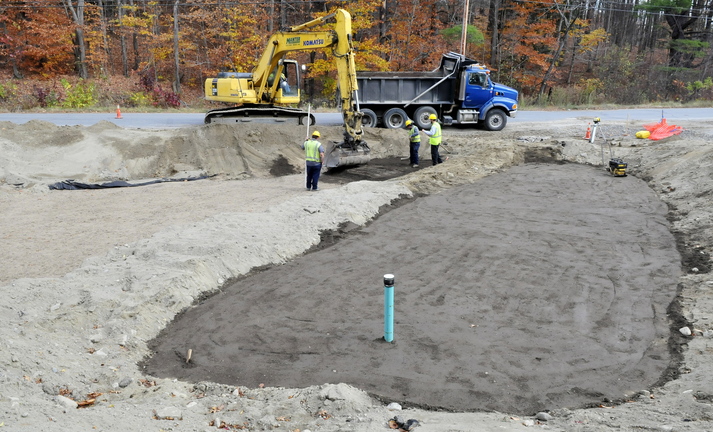 COVERED: Workers with Manter Construction cover a filtration system in Skowhegan on Monday. The system will help remove contaminated runoff water and will benefit the trout population in Whitten Brook.
