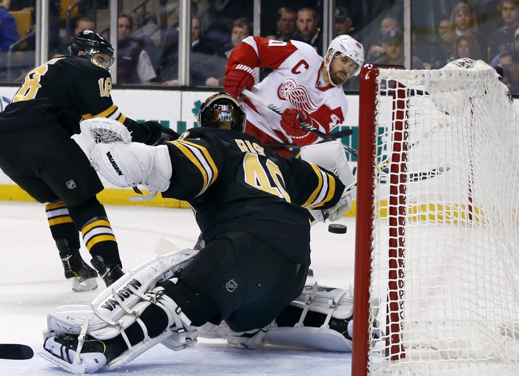 Detroit Red Wings center Henrik Zetterberg (40) shoots and scores against Boston Bruins goalie Tuukka Rask (40) as Bruins right wing Reilly Smith (18) defends, at left, in the first period of an NHL hockey game in Boston, Monday, Oct. 14, 2013.