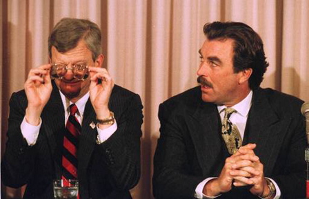 Author Tom Clancy, left, adjusts his glasses as actor Tom Selleck looks on, in this 1994 photo.