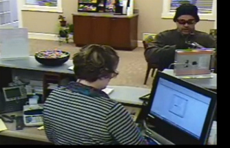 This image taken from a surveillance video shows a man robbing a teller at the Ocean Communities Federal Credit Union in Sanford on Saturday. Police say Philip Gage was the culprit.