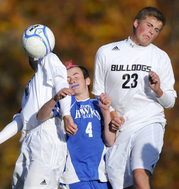 TIGTH QUARTERS: Hall-Dale High School’s Konnor Longfellow, left, and Ryan Sinclair sandwich Sacopee Valley High School’s Devin Day during the Bulldogs’ 2-0 win over Sacopee Valley in a Western C quarterfinal Wednesday in Farmingdale.