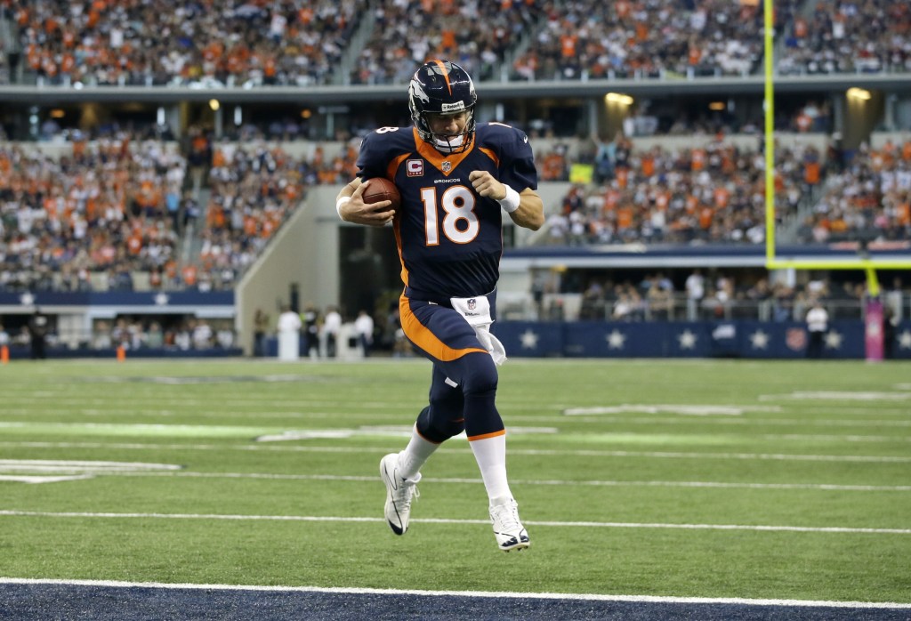 Denver Broncos quarterback Peyton Manning (18) sprints to the end zone untouched for a touchdown on a quarterback keep play in the first half of an NFL football game against the Dallas Cowboys, Sunday, Oct. 6,2013, in Arlington, Texas.