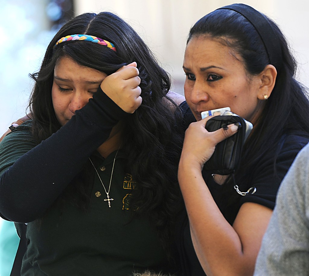 A tearful Michelle Hernandez, left, is led away from Agnes Risley Elementary School following a shooting at Sparks Middle School in Sparks, Nev. on Monday. Police on Tuesday said the boy who opened fire brought the weapon from his home.